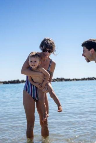 Glückliche Familie spielt im Meer unter der Sonne.